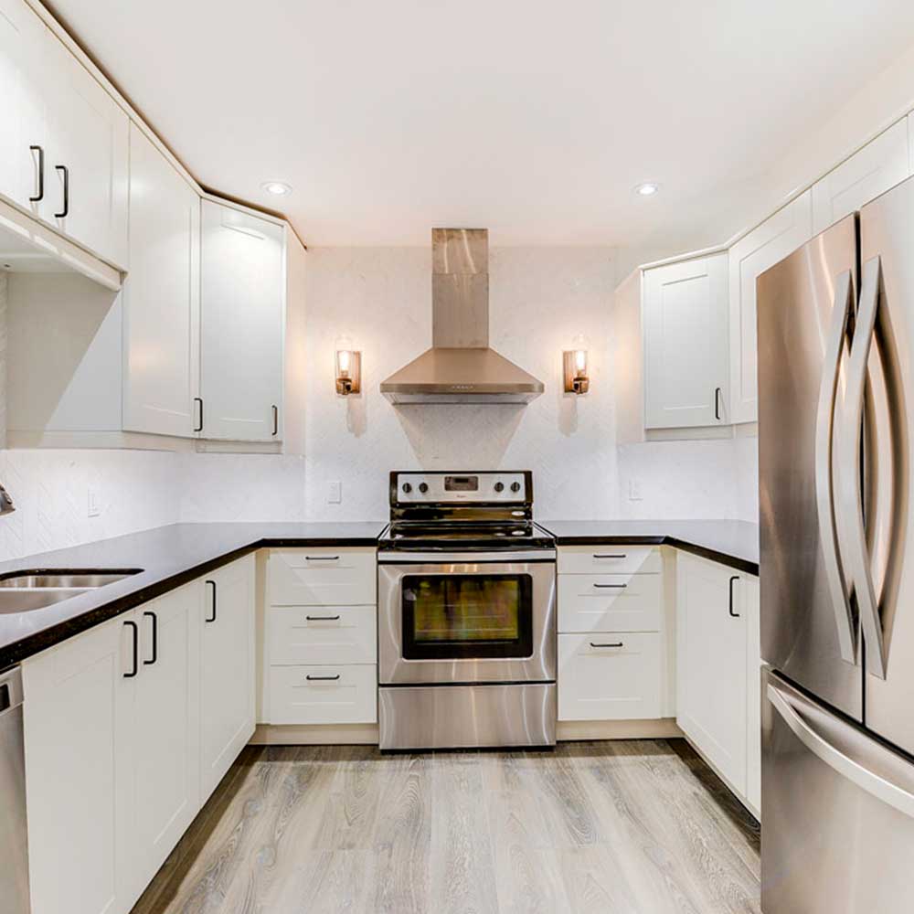 White shaker kitchen with a farmhouse sink and subway backsplash.