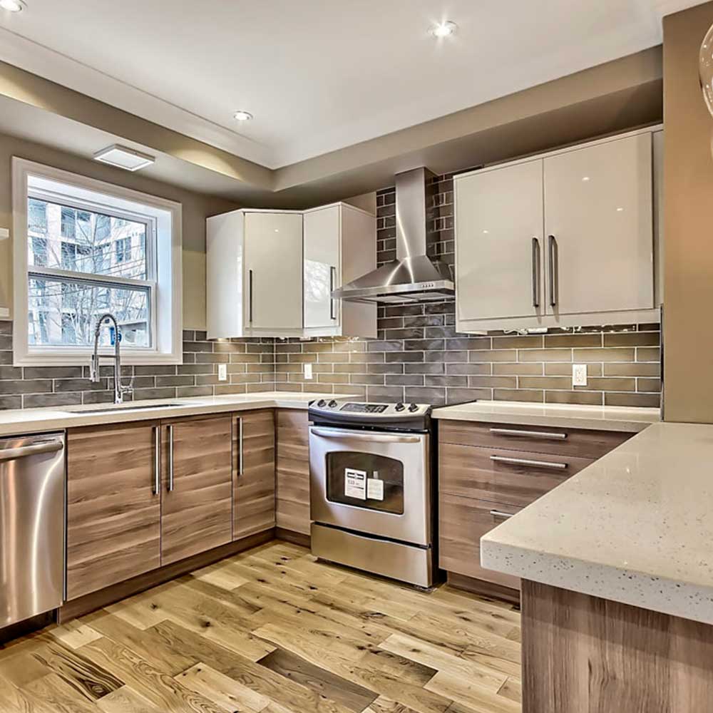 Cozy L-shaped layout with soft white cabinets and warm tones.