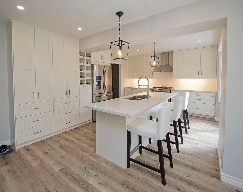Modern white shaker kitchen renovation in Toronto with island and wine storage